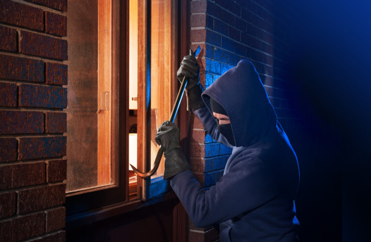 Burglar Using Crowbar To Break Into a House at night with room l